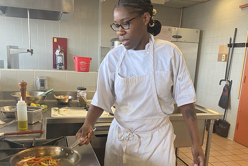 Drexel student Charmaine Patterson cooks food in the kitchen at the University. 
